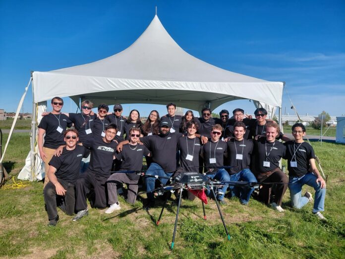 Blackbird team members stand in front of a white tent.