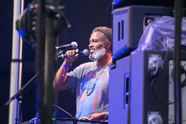 Man grins while holding mic on stage