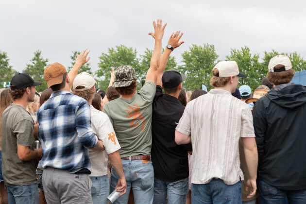 Men raising their hands in a crowd