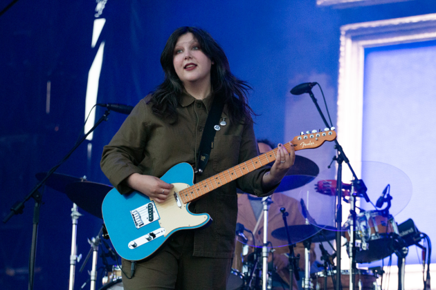 Woman sings while playing guitar