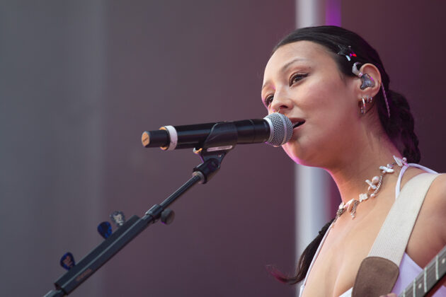 Woman sings smiling into mic