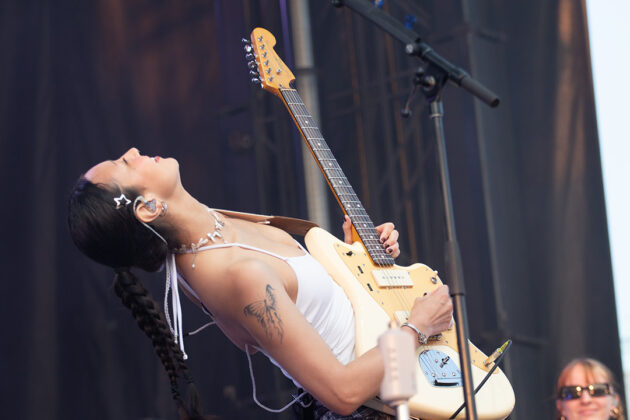 Woman leans back with guitar