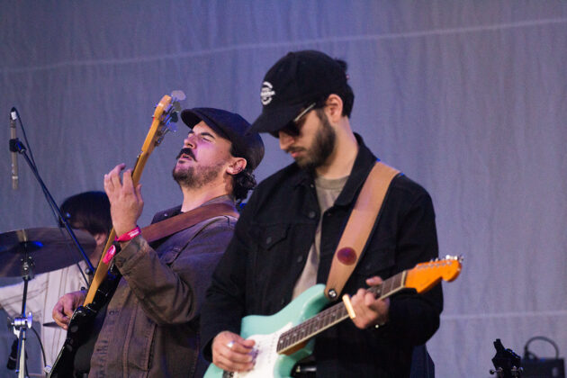 Two guitarists play on indoor stage