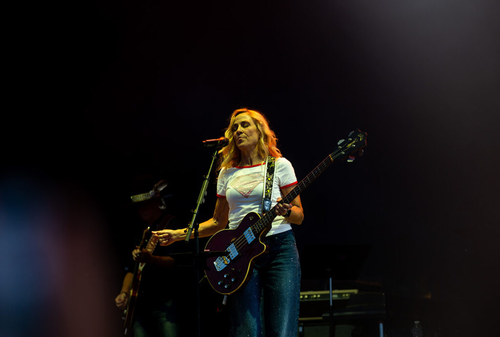 Woman sings while holding guitar